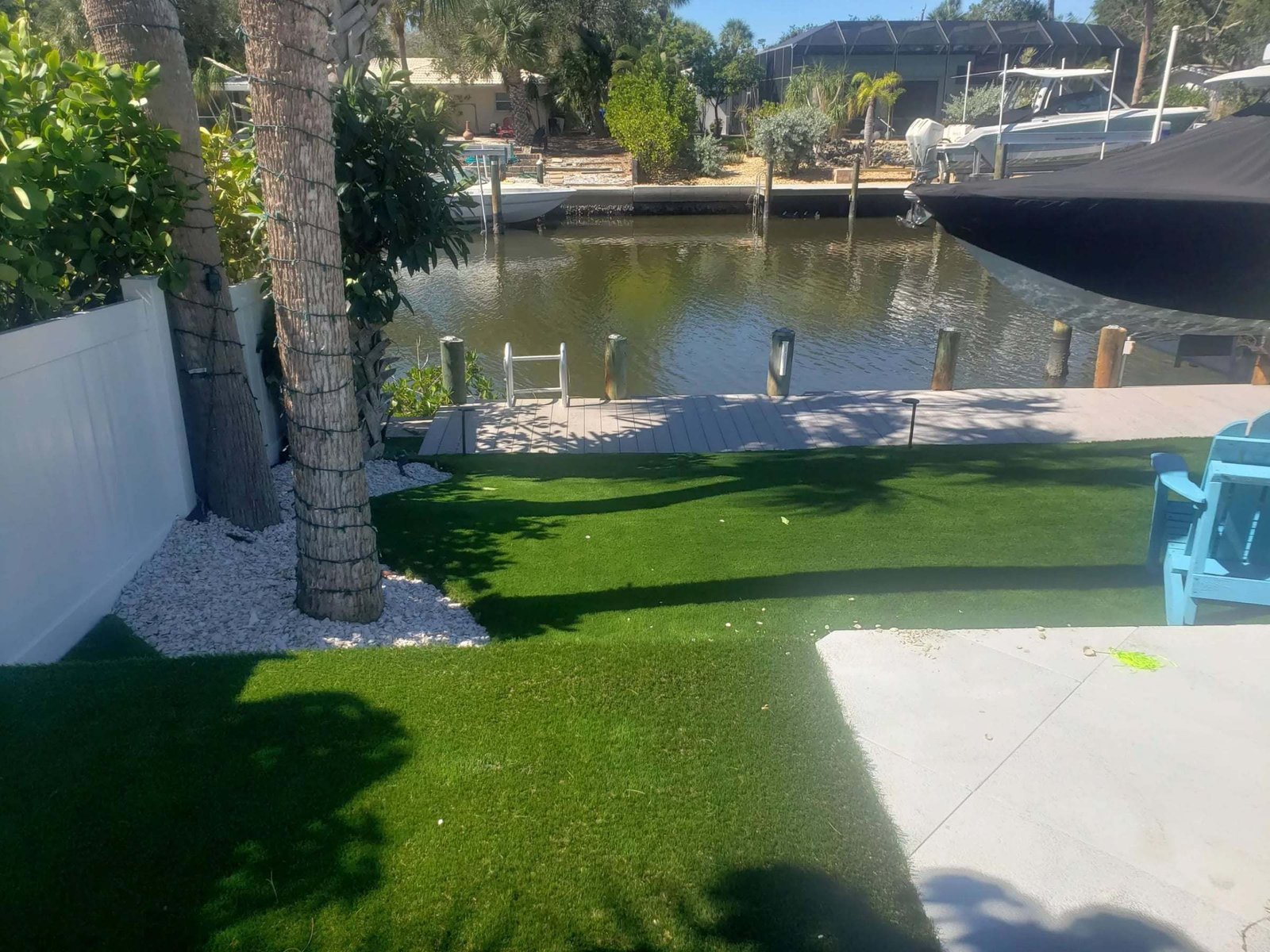 Canal-front backyard with artificial turf down to the dock, installed by ProTurf Solutions