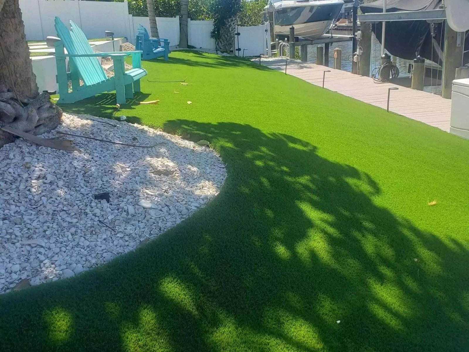 Side yard artificial turf with a white rock border, installed by ProTurf Solutions