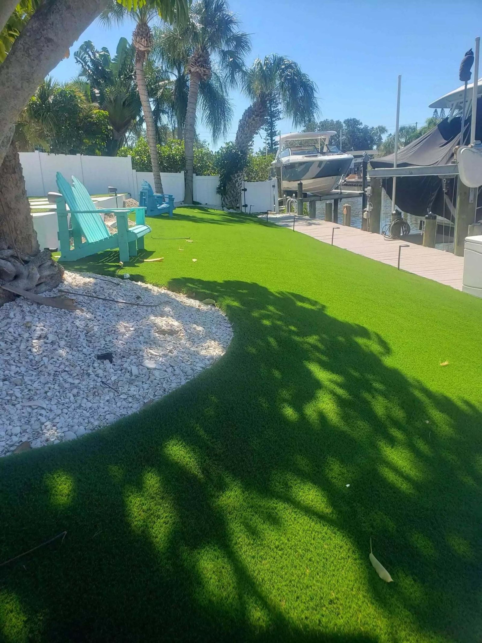 Side yard artificial turf with a white rock border, installed by ProTurf Solutions