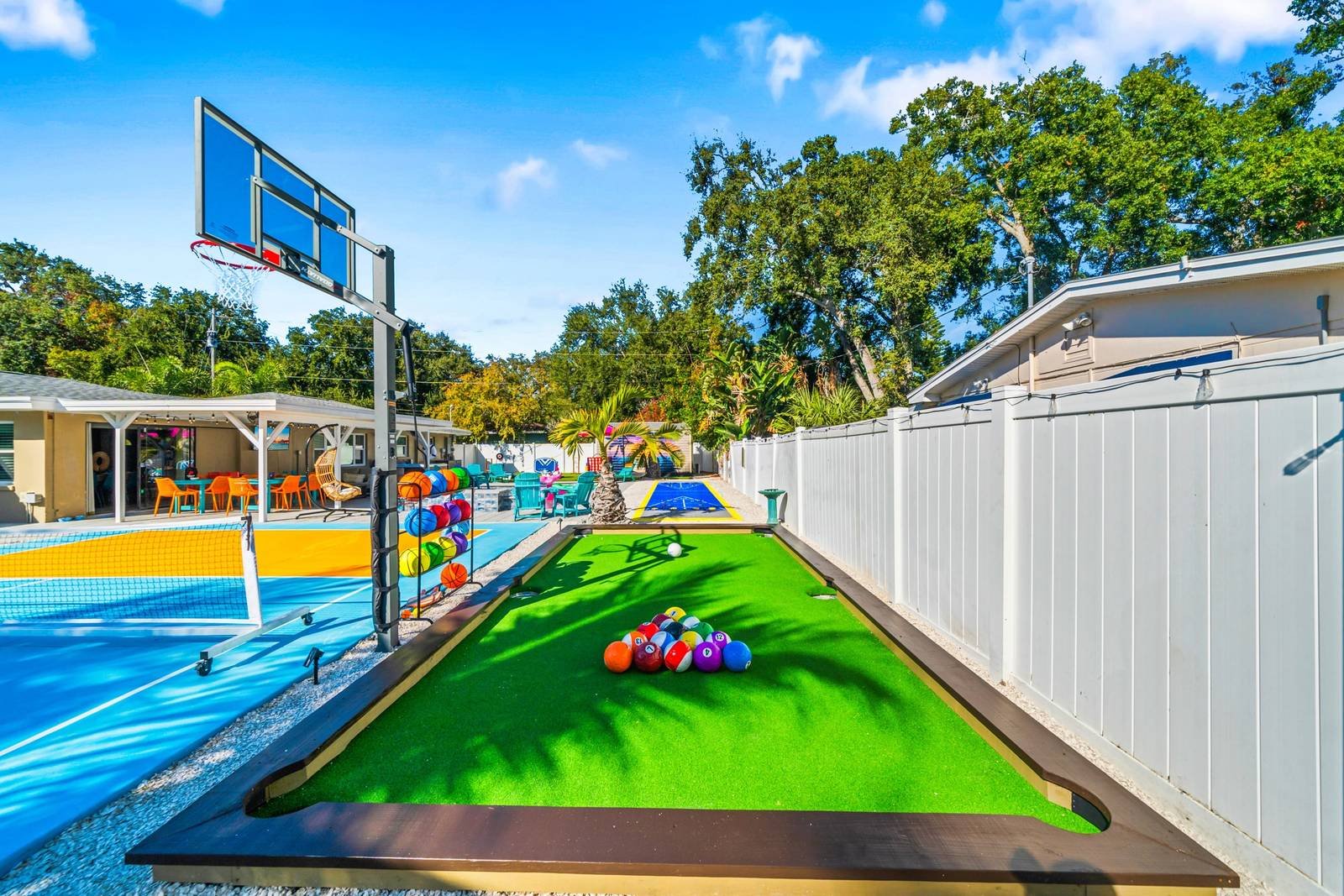 Turf billiards table beside a basketball hoop and sport court, installed by ProTurf Solutions