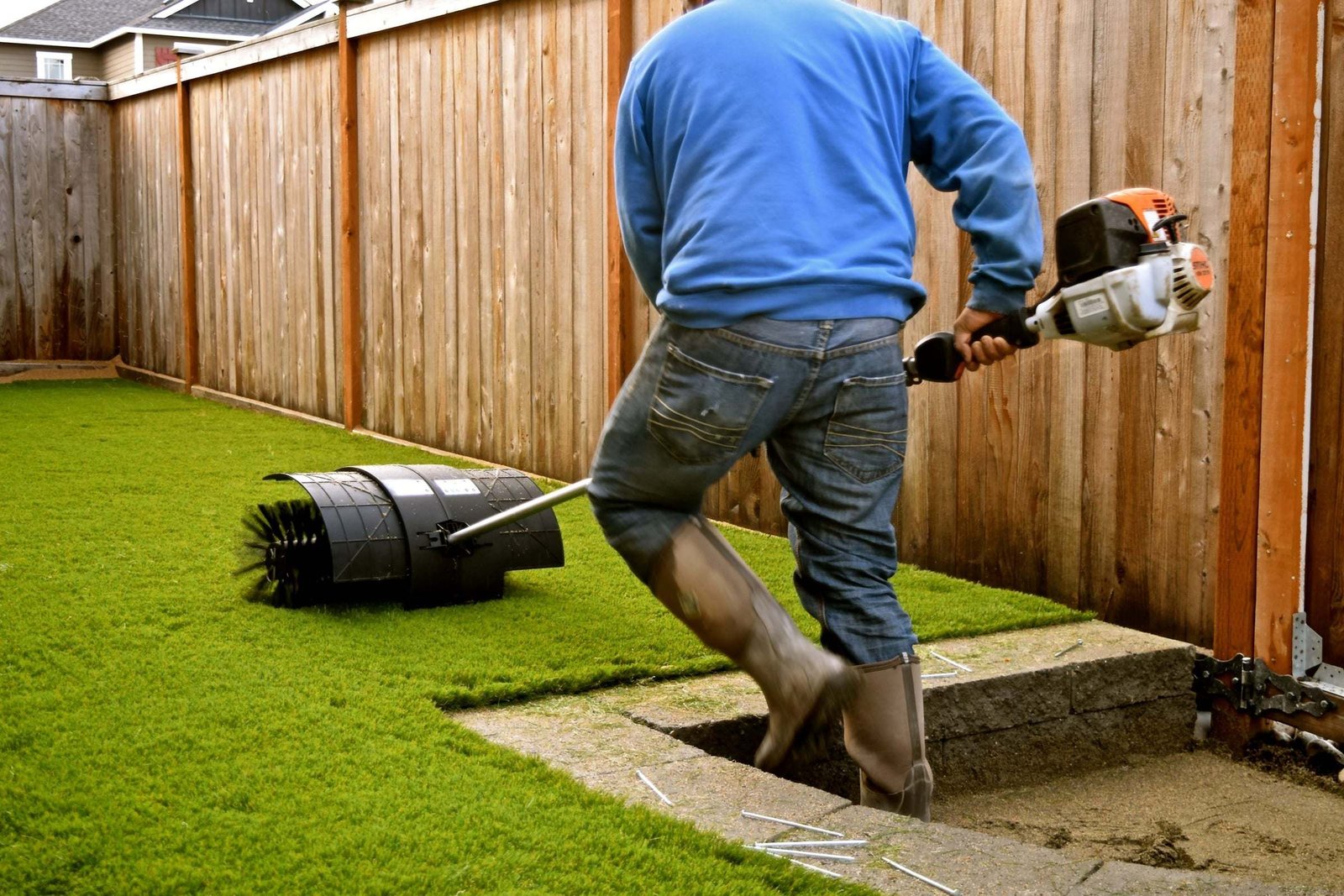 Turf installer working on a backyard artificial grass install
